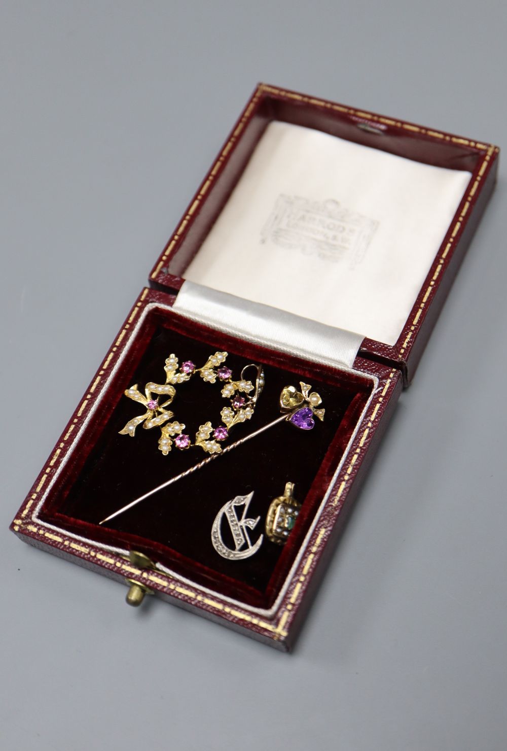 An early 20th century 15ct and gem set pendant, 30mm, gross 3.3 grams, a gem set twin hearts stick pin and two other items